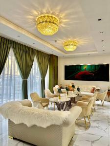 Base Ethiopia International Hotel في أديس أبابا: غرفة معيشة مع طاولات وكراسي وتلفزيون