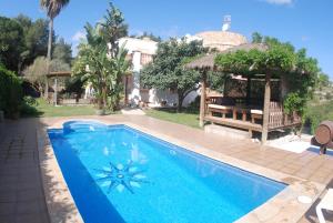 uma piscina num quintal com um gazebo em Can Pinato em Cala Llonga