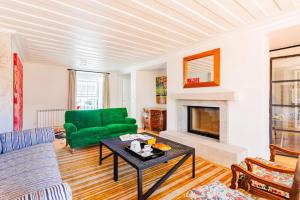 a living room with a green couch and a fireplace at Villa Azzurra Cascais 5BR in Cascais