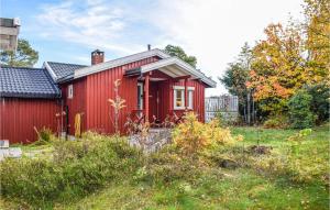 a red house with a red door in a yard at Beautiful Home In ros With Kitchen in Fagerstrand