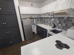 uma cozinha com armários brancos e um frigorífico em Апартамент Фамилия 100м от морето в Равда em Ravda