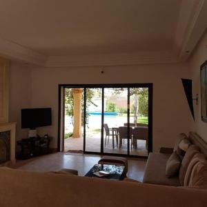 Sala de estar con sofá y vistas a una mesa en Exceptionnelle Villa duplex 3 ch avec piscine privée dans résidence fermée, en Riaïna