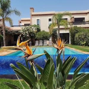 a swimming pool in front of a house at Exceptionnelle Villa duplex 3 ch avec piscine privée dans résidence fermée in Riaïna