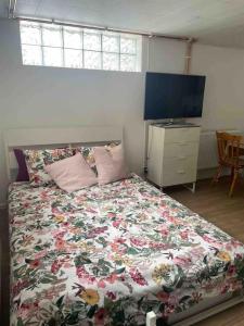 a bedroom with a bed with a floral bedspread at La Casita - all in one studio in Haninge in Västerhaninge