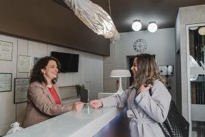 two women standing at a counter in a kitchen at Caro Boutique Hotel in Oradea