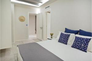 DexamenesにあるBoutique Mykonos Villa - Heated Hot-Tub - Wonderful views - Villa Heart - Agia Sofiaのベッドルーム1室(青と白の枕が備わるベッド1台付)