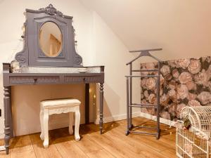 a dressing table with a mirror and a stool at La Villa des Roses - Suite & Spa in Lys-lez Lannoy