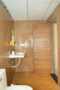 a bathroom with a wooden door and a sink at Swayamkrushi 4th floor in Hyderabad