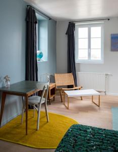 a living room with a table and a dining room at La Maison Plûme in Villequier