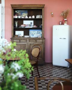 cocina con nevera y mesa con sillas en La Maison Plûme en Villequier