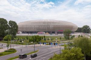 a large building in front of a parking lot at Solaris Park Apartments Tauron Arena by Renters Prestige in Kraków