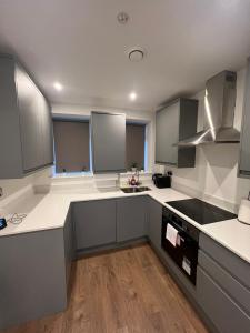 a large kitchen with white counters and gray cabinets at Sleep 10 London Chelsea Bridge Tower bridge WRC in London