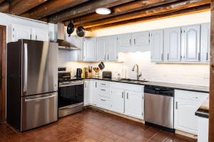 a kitchen with white cabinets and a stainless steel refrigerator at earthship forest exile 