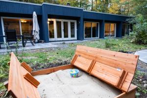 a wooden bench sitting in front of a house at earthship forest exile 