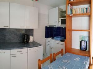 een keuken met witte kasten, een tafel en een magnetron bij Appartement Argelès-sur-Mer, 2 pièces, 6 personnes - FR-1-388-19 in Argelès-sur-Mer