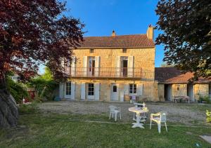 ein Haus mit einem Tisch und Stühlen im Hof in der Unterkunft Maison Sainte-Sabine Castels in Castels