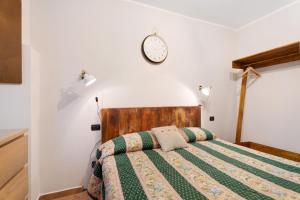a bedroom with a bed with a clock on the wall at Niky in Anzino