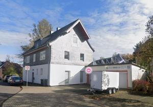 a large white house with a garage in front of it at Das alte Kutscherhaus - Table View 1C in Siegen