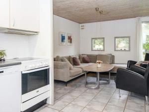 a kitchen and living room with a couch and a table at 8 person holiday home in rsted in Kare
