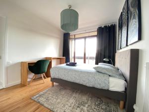 1 dormitorio con cama y ventana en La Lassolas - Charmant T2 avec Balcon et Garage, en Chamalières