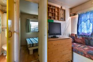 a living room with a tv on a dresser in a tiny house at Casetta Mobile al mare di Cavo in Cavo