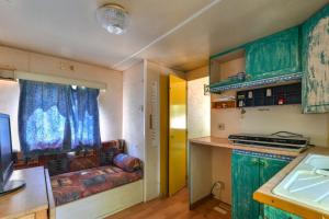 a kitchen with green cabinets and a couch in a kitchen at Casetta Mobile al mare di Cavo in Cavo