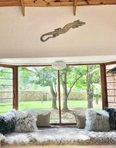 a living room with a couch and a large window at Critchely Stone Villa, Dullstroom in Dullstroom