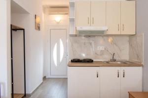 eine Küche mit weißen Schränken und einem Waschbecken in der Unterkunft STAR PARADISE Studios in Neos Marmaras
