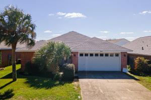 a house with a white garage and a palm tree at WINDSTARR DESTIN- Golf Cart Included, One level, Close to beach, Pet friendly in Destin