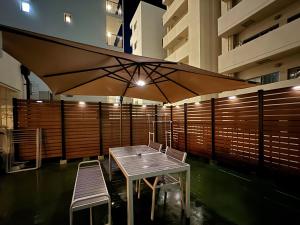 une table, deux chaises et un grand parasol dans l'établissement 桜Inn-通天閣403, à Osaka
