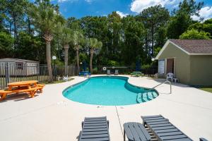 einen Pool mit Stühlen, einem Tisch und einer Bank in der Unterkunft WINDSTARR DESTIN- Golf Cart Included, One level, Close to beach, Pet friendly in Destin