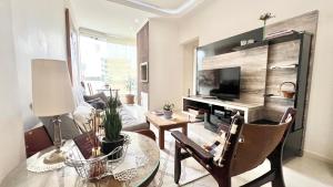 uma sala de estar com uma mesa e uma televisão em Apto Próximo a Vila Germânica em Blumenau