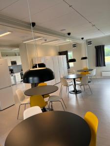 una habitación vacía con mesas, sillas y luces en Kiruna City Room, en Kiruna