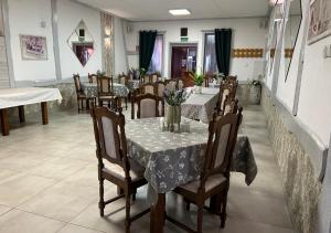 un comedor con mesas y sillas con flores. en Ostrzycka Gościna u Maryli, en Ostrzyce