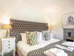 a bedroom with a large bed with a large headboard at Gate Lodge in Fettercairn