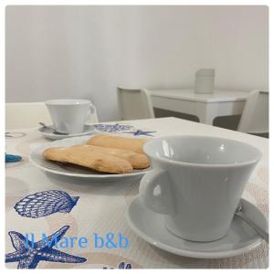 een tafel met een beker en borden eten erop bij Il mare b&b in Quartu SantʼElena