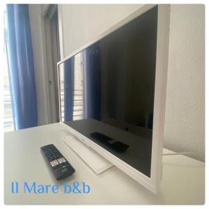 een tv op een tafel met een afstandsbediening bij Il mare b&b in Quartu SantʼElena