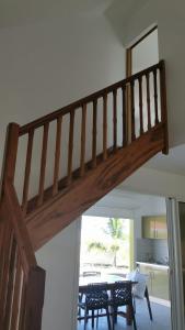 escalera de madera en una sala de estar con mesa en Cap des Anses en Sainte-Anne