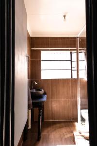 ein Bad mit einem Waschbecken und einem Fenster in der Unterkunft Latona Guest House in Johannesburg