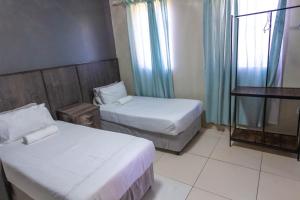 a hotel room with two beds and a window at Latona Guest House in Johannesburg