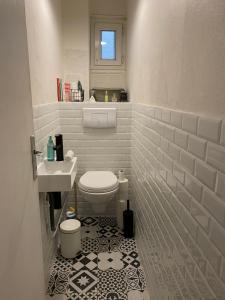 a white bathroom with a toilet and a sink at Paris en 10 min, T3 dans le centre ville de Puteaux in Puteaux