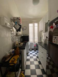 a kitchen with a black and white checkered floor at Paris en 10 min, T3 dans le centre ville de Puteaux in Puteaux
