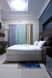 a bedroom with a bed and a blue curtain at Latona Guest House in Johannesburg