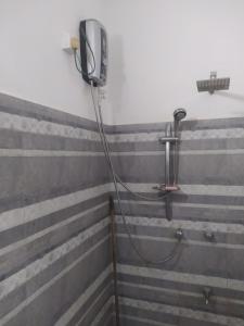 a shower with a hose attached to a wall at SuPra Villa in Ginimellagaha West