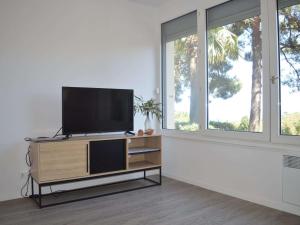 a flat screen tv sitting on a stand in a room with windows at Appartement Banyuls-sur-Mer, 3 pièces, 5 personnes - FR-1-225C-77 in Banyuls-sur-Mer