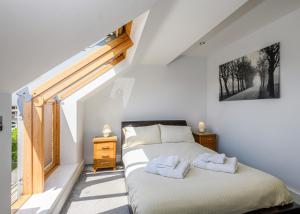 a bedroom with a bed with two towels on it at Bay Retreat Villas in St Merryn