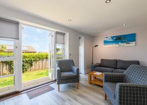 a living room with a couch and two chairs at Bay Retreat Villas in St Merryn