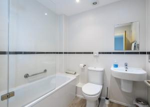 een witte badkamer met een toilet en een wastafel bij Bay Retreat Villas in Saint Merryn