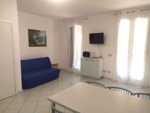 sala de estar con sofá azul y TV en Holiday Homes in Rosolina Mare 24977, en Rosolina Mare