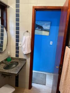 een badkamer met een wastafel en een blauwe deur bij Quarto com banheiro no térreo in Araruama